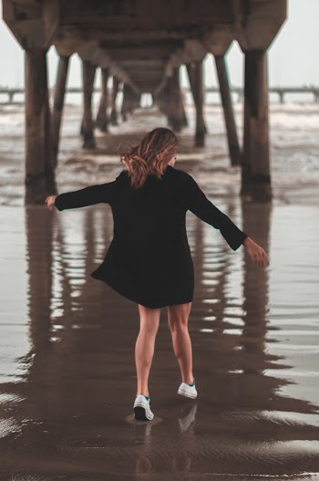Woman Walking Under Wooden Bridge