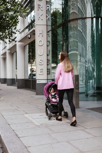 woman walking with child inside stroller