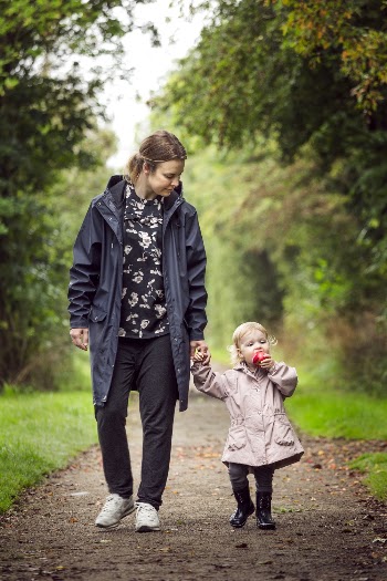 Woman Walking With Child on Pathway