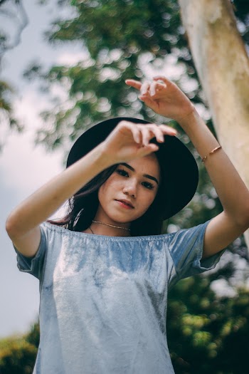 Woman Wearing A Black Hat With Hands Up