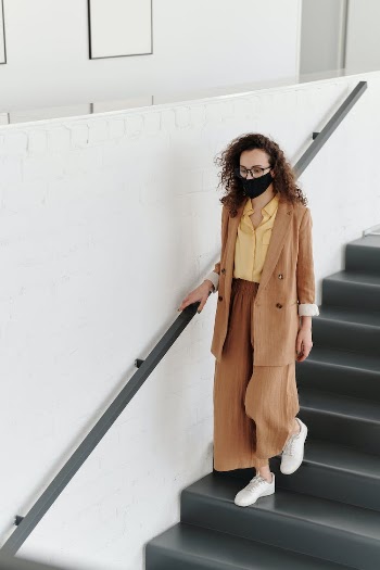 Woman Wearing a Face Mask Walking Down Stairs