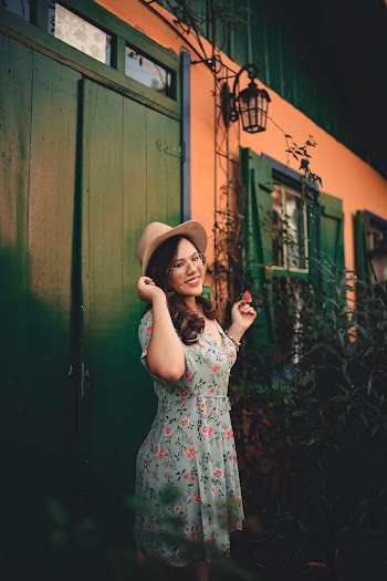 Woman Wearing A Floral Dress Holding Brown Hat
