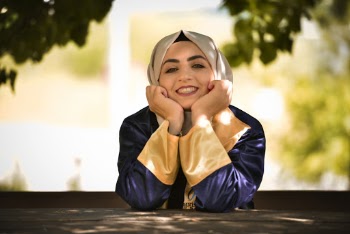 Woman wearing a hijab and sitting on a bench