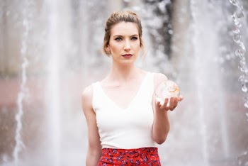 Woman wearing a white top  holding a glass ball