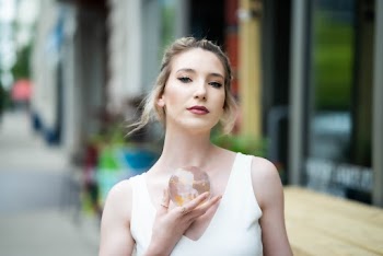 Woman wearing a white Top holding a glassball