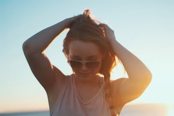 woman wearing beige tank top against sunrise