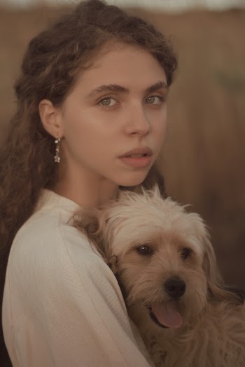 Woman Wearing Beige Top Carrying Her Dog