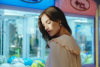 Woman Wearing Beige Top Near Arcade Machine