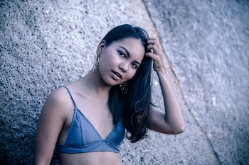 Woman Wearing Bikini Tops Leaning on Gray Surface