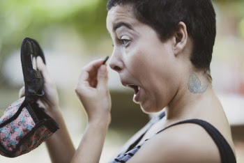 Woman Wearing Black and Gray Tank Top Putting Makeup While Holding Compact Mirror