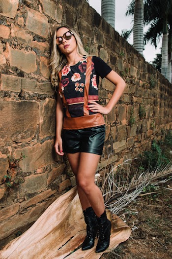 Woman Wearing Black and Red Floral Print Crew-neck Shirt Beside Brown Brick Wall