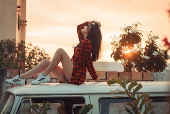 Woman Wearing Black and Red Plaid Dress Shirt Sitting on Car Roof