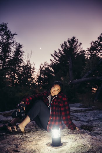Woman Wearing Black and Red Plaid Jacket in Front of Lamp