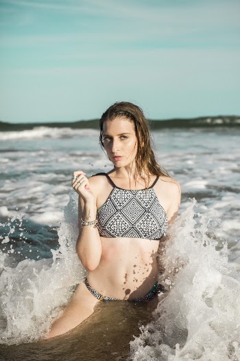 Woman Wearing Black and White Bikini Sitting on Beach Shore