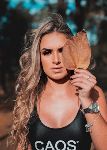 Woman Wearing Black and White Caos Top Holding Brown Leaf