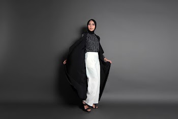 Woman Wearing Black And White Outfit Standing Against Wall