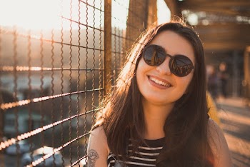 Woman Wearing Black and White Stripe Top Besides Brown Steel Mat Fence