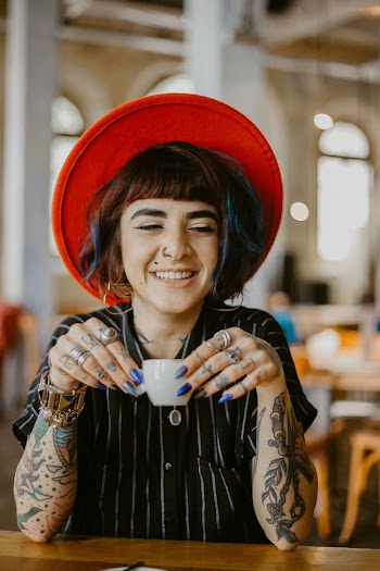 Woman Wearing Black And White Striped Button-up Shirt And Red Hat Holding White Ceramic Teacup