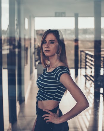 Woman Wearing Black and White Striped Crop Top Standing With Left Arm Akimbo Inside Room