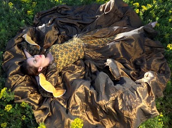 Woman Wearing Black and Yellow Dress Laying on Green Grass