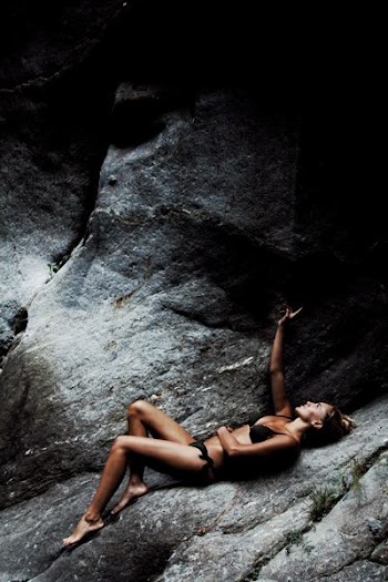 woman wearing black bikini lying on rock