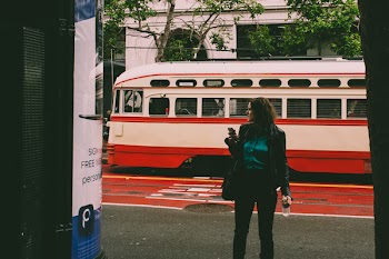 Woman Wearing Black Blazer Beside White and Red Cable Cab