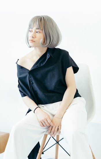 Woman Wearing Black Blouse and White Pants Sitting on Chair
