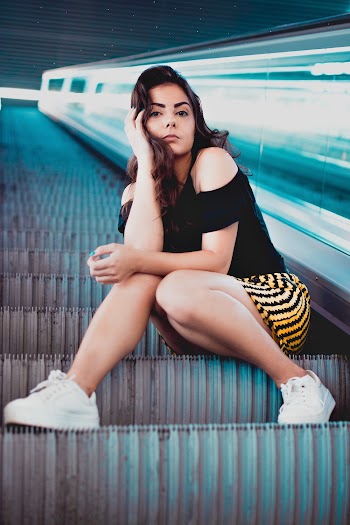 Woman Wearing Black Blouse Sitting on Escalator