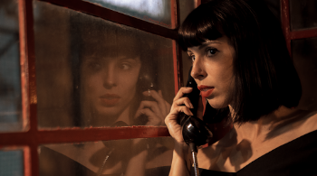 Woman Wearing Black Blouse Standing While Using Telephone
