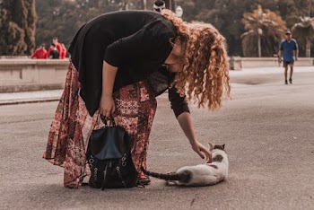 Woman Wearing Black Cardigan and Maroon and White Floral Maxi Skirt Holding Black Knapsack