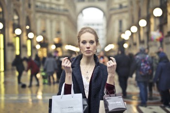 Woman Wearing Black Coat Holding Assorted-color Shopping Bags on Building