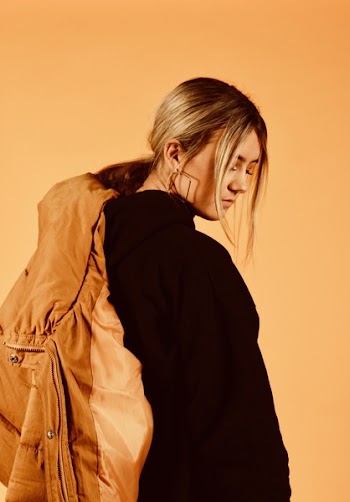 Woman Wearing Black Coat Holding Brown Jacket