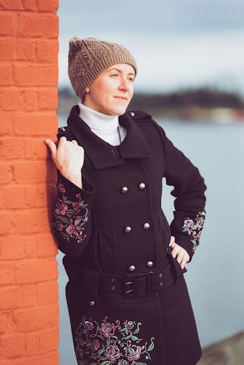 Woman Wearing Black Coat Standing Near the Wall