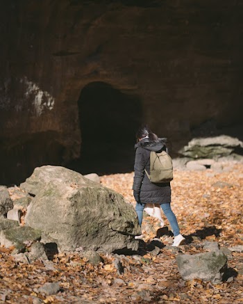 Woman Wearing Black Coat Walking Beside Rock