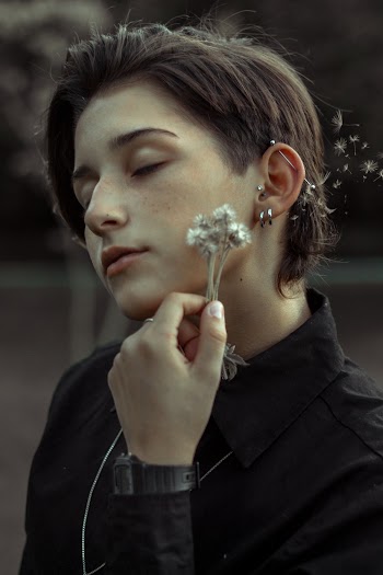 Woman Wearing Black Collared Shirt holding a flower