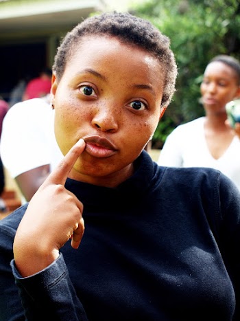 Woman Wearing Black Crew-neck Long-sleeved Shirt Putting Finger Near Her Mouth