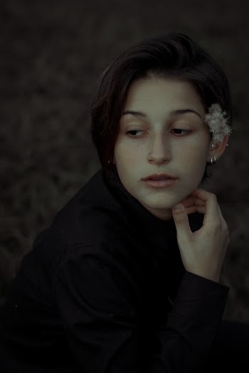 Woman Wearing Black Crew-neck Long-sleeved Shirt Sitting and Looking Her Right Side