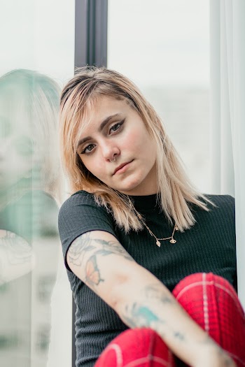Woman Wearing Black Crew Neck Shirt Leaning On Clear Glass Window
