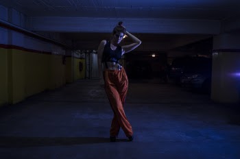 Woman Wearing Black Crop-top and Orange Pants Inside Parking Lot