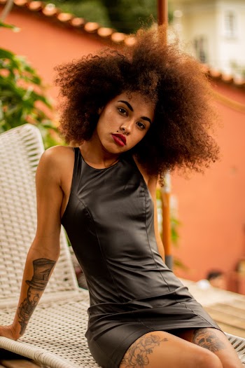 Woman Wearing Black Dress Sitting on White Surface