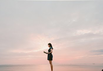 Woman Wearing Black Dress Standing and Reading Book