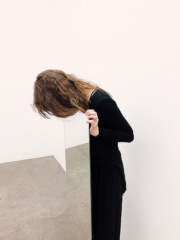 Woman Wearing Black Dress Standing Near Brown Wall