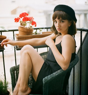 Woman Wearing Black Dress While Sitting on Chair