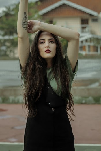 Woman Wearing Black Dress With Right Hand Raise