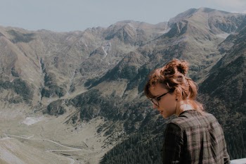 Woman Wearing Black Frame Eyeglasses Facing Green Mountains