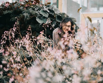 Woman Wearing Black Framed Eyeglasses Standing Near Flowers