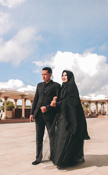 Woman Wearing Black Hijab Holding Man in Black Suit 