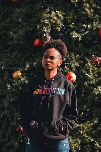 Woman Wearing Black Hoodie While Standing Near Christmas Tree