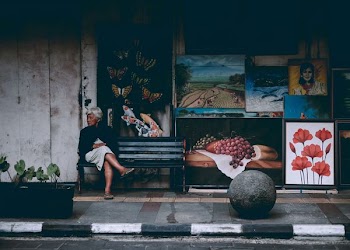 woman wearing black jacket and white skirt sitting on the bench
