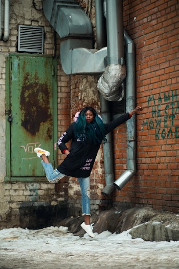 Woman Wearing Black Jacket Near Red Concrete Bricks